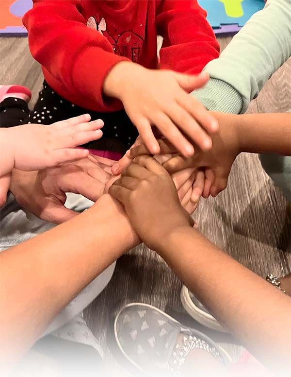 Photo 5: Children of different ethnicities stacking hands on one another