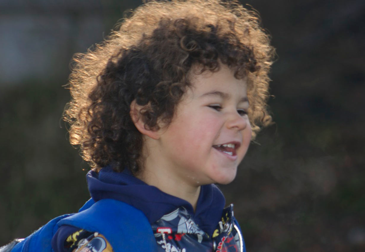 happy child with curly hair outdoors
