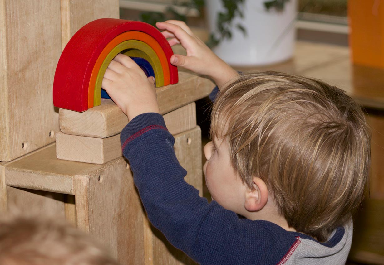 a child playing with rainbow blocks